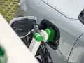 Zielony kabel ładowarki podłączony do portu ładowania samochodu elektrycznego.