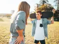 Ein Junge mit einem Skateboard über der Schulter spricht mit einer Frau. Die **Adoleszenz** ist eine spannende Zeit voller Entdeckungen.