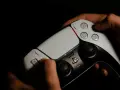 Manos sujetando un mando de PS5, intentando arreglar el drift.