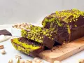 Saftiger Schokoladen-Pistazienkuchen mit Schokoladenglasur und gehackten Pistazien. Die grünen Streifen im Kuchen und die Pistaziencreme machen ihn zu einem besonderen Genuss.