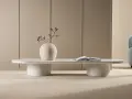Vitt, ovalt soffbord med en vas med blommor och en öppen bok. Perfekt för att visa soffbord mått i ett stilrent hem.
