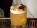 Elegancki Whisky Sour i Amaretto Sour z pianką i dekoracją na barze.