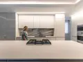 Cocina moderna con iluminación LED integrada en los gabinetes y el techo, ideal para saber como iluminar una cocina.