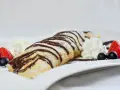 Palatschinken mit Eis, Schokosauce und frischen Beeren. Ein süßer Genuss, der auf der Zunge zergeht.