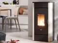 Stufa a pellet moderna in funzione, con fiamme vive. L'installazione stufa a pellet con canna fumaria è discreta, integrata in un ambiente cucina/soggiorno accogliente.