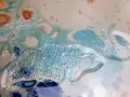 Peinture abstraite aux couleurs vives, évoquant la technique de comment faire du vernis avec de l'eau. Des formes fluides bleues, blanches et orangées se mélangent.