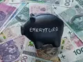 Czarna skarbonka z napisem "EMERYTURA" na tle polskich banknotów. Zastanawiasz się, jaka emerytura przy zarobkach 7000 brutto?