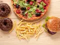 Pizza, burger, frytki i pączki z czekoladą – uczta pełna tłuszczów nasyconych.
