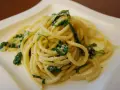 Bucatini z zielonymi liśćmi i parmezanem, pyszne danie, które może konkurować ze spaghetti.