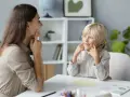 Terapeuta pracuje z 4-latkiem, który wykazuje echolalię. Dziecko powtarza dźwięki, a terapeuta cierpliwie go wspiera.
