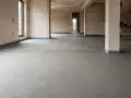 Surowa posadzka betonowa z widoczną linią dylatacji, przygotowana do dalszych prac wykończeniowych.