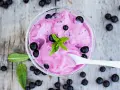Ein Schälchen mit cremigem Johannisbeer Eis, garniert mit frischer Minze und ganzen Beeren.