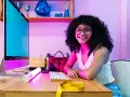 Giovane donna sorridente al computer, pronta a diventare e-commerce manager. Sul tavolo, un metro da sarta giallo.