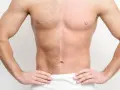 Torso de hombre con la mitad del pecho y abdomen con vello y la otra mitad completamente lisa, mostrando el resultado del afeitado corporal hombre.