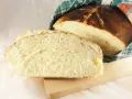 Pyszny, domowy chleb wielkanocny, pokrojony w kromki, z chrupiącą skórką i puszystym wnętrzem, owinięty w tradycyjny ręcznik.