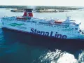 Stena Spirit, duży prom Stena Line, płynie po błękitnym morzu, z zielonymi liśćmi i napisem "Connecting.Europe" na burcie.