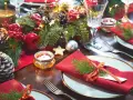 Vackert dukat julbord med röda servetter, granris, äpplen, kottar och ljus. Här ser du vad man har på ett julbord för att skapa julstämning.