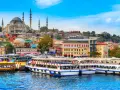 A vibrant cityscape of Istanbul, with the Suleymaniye Mosque dominating the skyline. Ferries and buses line the waterfront, ready for a 3-day Istanbul adventure.