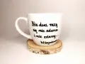 Biały kubek z cytatem Wisławy Szymborskiej: "Nic dwa razy się nie zdarza i nie zdarzy...". Wczoraj kiedy twoje imię ktoś wymówił przy mnie głośno wiersz.
