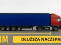 Czerwona ciężarówka z niebieską naczepą na drodze. Napis "1,3M DŁUŻSZA NACZEPA!".