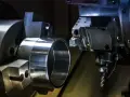 Precyzyjne toczenie metalowego pierścienia. Narzędzie z płytkami do noży tokarskich z katalogu precyzyjnie obrabia detal.