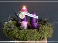 Wieniec adwentowy z zapaloną świecą, ozdobiony mchem, szyszkami i gałązkami. "Nadzieja budzi serce" - napis na pierwszej niedzieli adwentu.