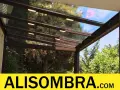 Techo de cristal para montera patio interior, con luces integradas y vistas a árboles frondosos.