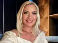 Uśmiechnięta Joanna Janikowska-Samojłowicz w białej bluzce z odkrytymi ramionami, z naszyjnikami na szyi.