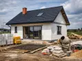 Budowa domu 80 m: bloczki, cement, zbrojenie i betoniarka czekają na rozpoczęcie prac.