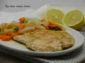 Fettine di tacchino appetitose, cotte alla griglia, servite con verdure miste e spicchi di limone.