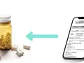 Butelka z kapsułkami i smartfon z receptą. Czy witamina E jest na receptę? Zobacz, jak uzyskać e-receptę.