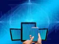 Grafiki bez praw autorskich: nowoczesne urządzenia (smartfon, tablet) na tle cyfrowego kodu binarnego.