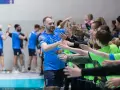Gracz MKS Wieluń w niebieskiej koszulce z numerem 1 daje "piątki" młodym kibicom.