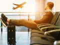 Mężczyzna czeka na lotnisku, nogi na walizce, samolot Wizzair startuje. Czyżby overbooking?