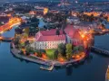 Ostrów Tumski we Wrocławiu nocą, z oświetlonymi budynkami i rzeką. To jedno z najpiękniejszych miejsc Wrocławia.