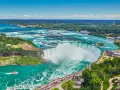 Potężne wodospady Niagara w pełnej krasie, gdzie jest niagara, z turkusową wodą i zielonymi brzegami.