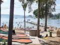 Minigolfbana vid Engesbergs camping. Många badar och solar vid vattnet, en brygga leder ut i sjön.