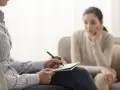 Psycholog notuje podczas sesji. Zastanawiasz się, ile zarabia psycholog prywatnie? To zależy od wielu czynników.
