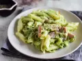 Penne z brokułami i kawałkami szynki w kremowym sosie śmietanowym, posypane serem. Pyszne danie, które zachwyci każdego.