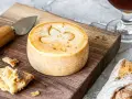 Un fromage rond, marqué d'une fleur de lys, prêt à être dégusté. Une invitation à découvrir comment faire du fromage.
