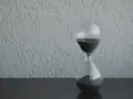 Clessidra con sabbia nera che scorre, simbolo del tempo che passa. Quanto tempo portare il lutto? Il tempo guarisce, ma il ricordo resta.
