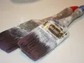 Deux pinceaux usagés, couverts de peinture blanche séchée. Que faire avec ce pinceau sec ?