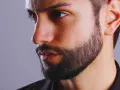 Primer plano de un hombre con barba cuidada, con un estilo fade beard que se difumina hacia las mejillas.