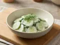 Frischer gurkensalat mit joghurt und dill in einer schüssel, garniert mit dill.