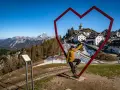 Kobieta w sercu z widokiem na górską wioskę Monte Lussari.