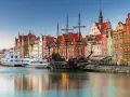 Gdański port z żaglowcem i kolorowymi kamienicami. To miejsce, co warto zwiedzić w Polsce, zachwyca historią i widokami.