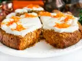 Pyszne ciasto marchewkowe fit z płatkami owsianymi, udekorowane kremem i startą marchewką. Idealne na zdrowy deser.