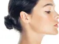 Profilo di donna con trucco leggero, evidenziato il contouring naso per un effetto scolpito. Pelle luminosa e capelli raccolti.