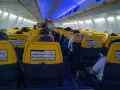 Widok na wnętrze samolotu z żółtymi zagłówkami i instrukcjami bezpieczeństwa. Rozkład miejsc w samolocie jest typowy dla tanich linii lotniczych.