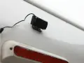 En liten svart backkamera monterad på en vit yta, redo att installera för bättre sikt bakåt.